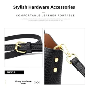Close-up of golden metal buckle and swivel hook on black lychee grain leather bag