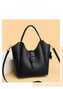 Detail of black lychee grain bucket bag featuring a top handle and adjustable strap
