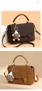 Detail of matte messenger bag featuring OUZUNO logo and monster charm decoration