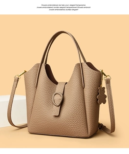 Close-up of brown pebbled leather texture with cute bear charm and golden hardware