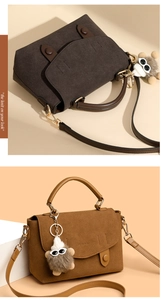 Detail of suede messenger bag with OUIUNO logo embossing and fur ball charm pendant