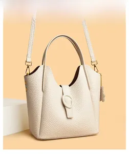 Detail of off-white lychee grain leather bucket bag with cloud charm and top handle