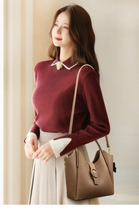 Brown lychee leather bucket bag with ring strap detail worn by model in casual setting