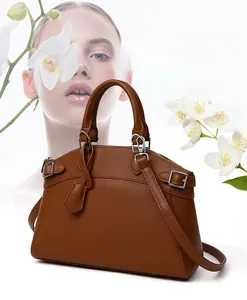 Close-up of brown lychee grain leather handbag with silver hardware and detachable strap