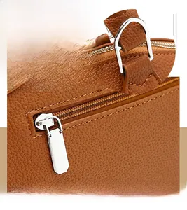 Close-up of brown pebbled leather bag with fine stitching and silver metal zipper detail