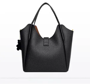 Rear view of black pebble leather bucket bag with cute bear charm and silver magnetic clasp