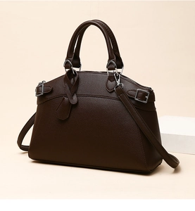 Detail of dark brown pebble leather handbag with silver buckles and tubular handles