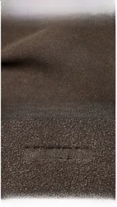 Close-up of deep brown suede texture with debossed CUZUNO logo on stylish messenger bag