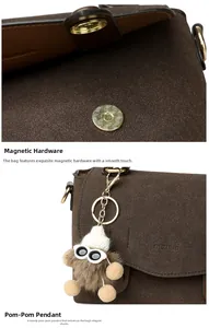 Detailed close-up of dark brown matte messenger bag with gold buckle and sunglasses charm