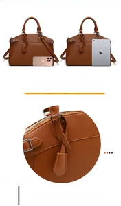 Detail of brown pebbled leather tote bag showing reinforced handles and fine stitching