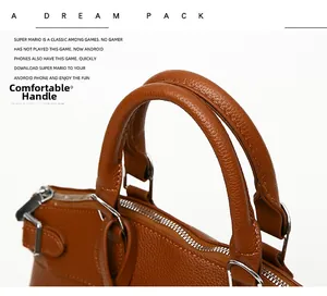 Detail of lychee pattern leather handles and metal zipper on a brown tote bag