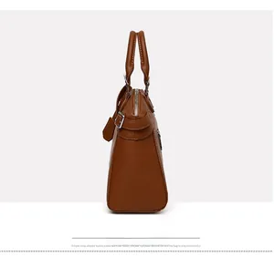 Detailed side view of brown lychee-textured leather tote with cylindrical handles