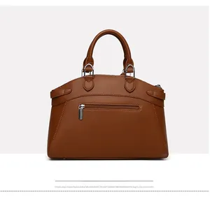 Close-up of brown litchi pattern leather bag showing silver hardware and smooth zippers