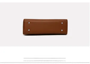 Detail of brown lychee grain leather handbag base with four silver metal feet