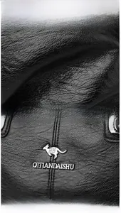 Dettaglio della borsa in pelle nera a grana litchi con logo a forma di canguro