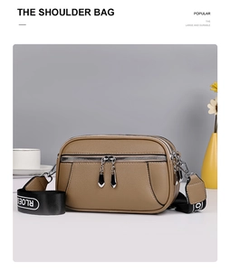 Detail of brown litchi pattern leather bag with triple zippers and wide printed strap