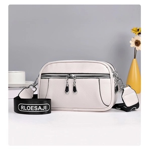 Detail of white crossbody bag with lychee grain leather and layered zipper structure