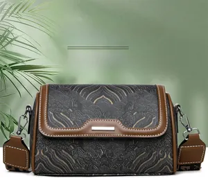 Detail of vintage embroidered Boston bag with grey cloud patterns and brown leather straps