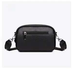 Detail of the back side of black crossbody bag with lychee texture and zipper pocket