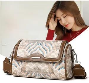 Close-up of retro embroidered Boston bag with traditional wave patterns and metal clasp