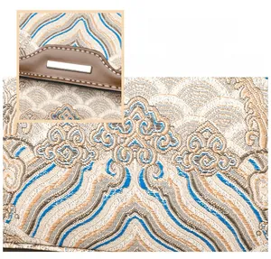 Detail of traditional Chinese embroidery pattern on jacquard fabric with brown leather trim