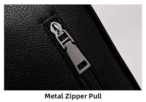 Detail of high-quality silver hardware zipper on black litchi grain leather bag