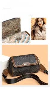 Detail of vintage crossbody bag featuring cloud embroidery and a wide textile strap
