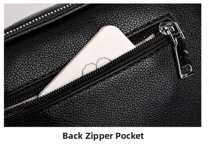 Close-up of back zipper pocket on black pebble leather crossbody bag with silver hardware