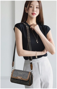 Detail of vintage embroidered Boston bag with golden wave patterns and wide strap