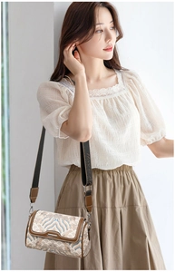 Detail view of retro embroidery pillow bag with traditional Chinese wave pattern on model