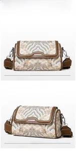 Macro detail of vintage embroidered satchel with golden clouds and leather trim