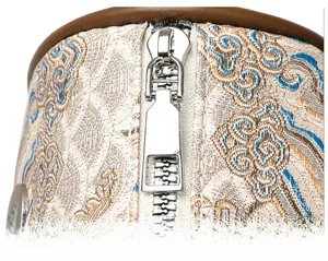 Detailed macro view of the silver metal zipper and traditional Chinese embroidery fabric