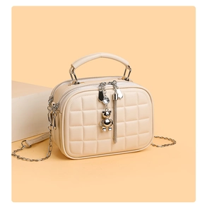Detail of cream quilted PU leather bag with silver bear charm and tassel ornament