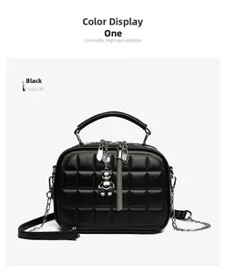 Detail of black quilted leather texture with silver bear charm and tassel on chain handbag