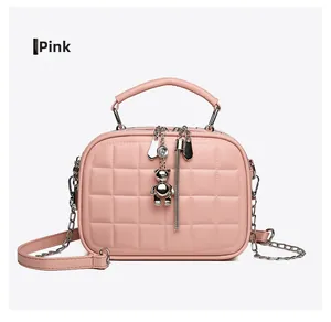 Detailed view of pink quilted handbag with gold chain strap and cute bear charm pendant