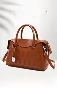 Détail du sac à main marron caramel en cuir litchi avec logo et poignées rondes
