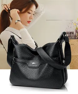Close-up of black lychee grain leather crossbody bag with metallic logo and zipper pocket