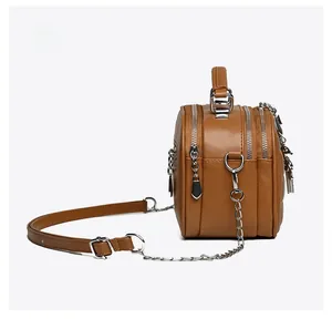 Detail view of brown PU leather crossbody bag featuring a triple-zipper storage structure