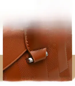 Détail du sac à main marron avec texture gaufrée et poche zippée pour un smartphone