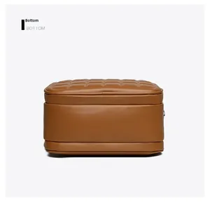 Detail view of the caramel brown lychee leather bottom with quilted stitching