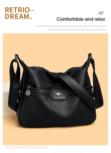 Detail of black pebbled leather crossbody bag with front zipper and golden kangaroo logo