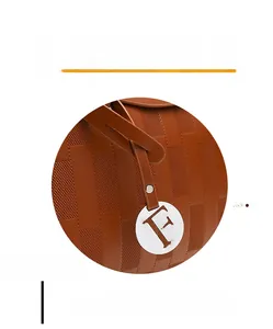 Détail macro de la texture gaufrée marron avec un pendentif rond argenté lettre F