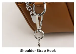 Detail of silver swivel lobster clasp and chain on brown leather shoulder bag
