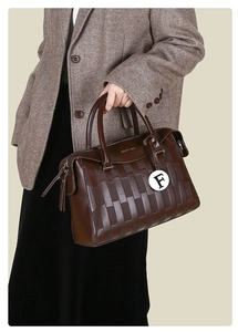 Détail du sac cabas marron foncé avec textures gaufrées et pendentif circulaire lettre F
