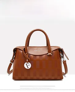 Vue détaillée d'un sac à main marron en similicuir avec texture gaufrée et pendentif