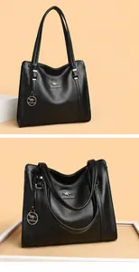 Dettaglio della borsa tote in pelle martellata nera con logo a canguro e ciondolo