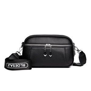 Black pebbled leather crossbody square bag with dual zippers and wide fabric strap
