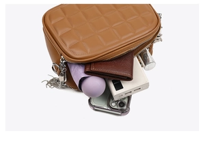 Brown quilted crossbody bag showing multiple zipper compartments and large storage capacity