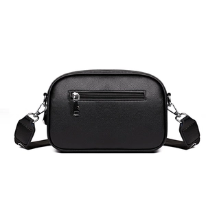 Minimalist black pebble leather crossbody camera bag with silver zippers and wide strap