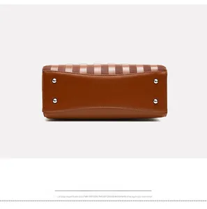 Vue détaillée du fond du sac à main marron avec quatre clous de protection en métal argenté